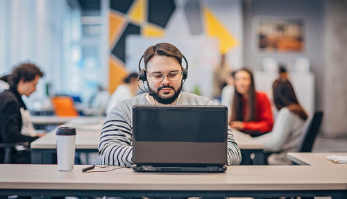 Employee working on laptop in big modern office