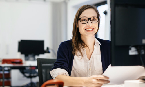 Casual business woman smiling at a desk in an office