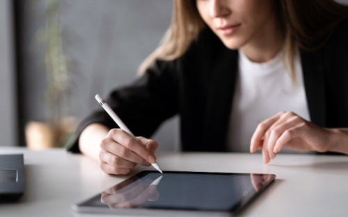 Una mujer firma un documento en su tableta