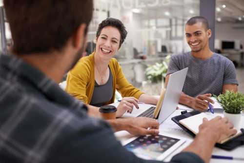 Un grupo de personas sonrien mientras trabajan juntas