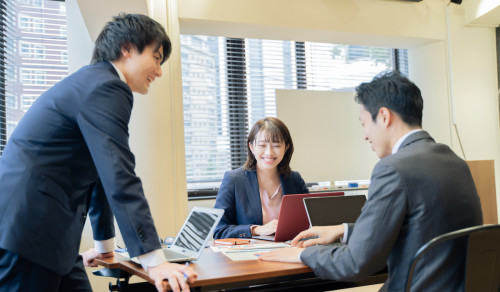 会議に参加する若い男性社員2人と女性社員1人