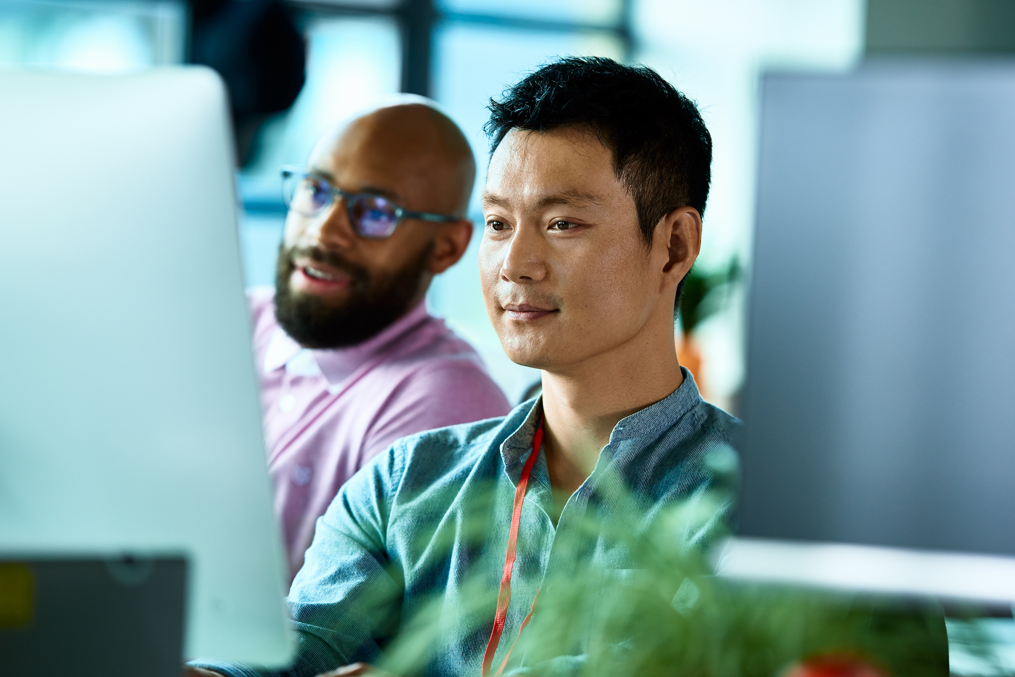 two men working and looking at desktop screen