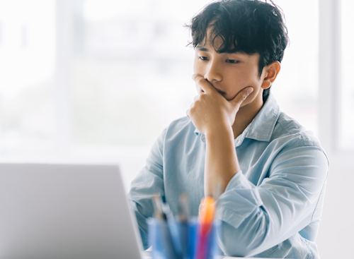 A man deep in thought in front of a computer