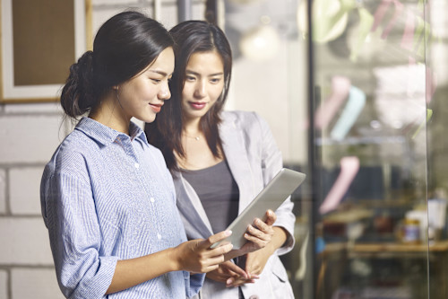 two women looking at tablet pc