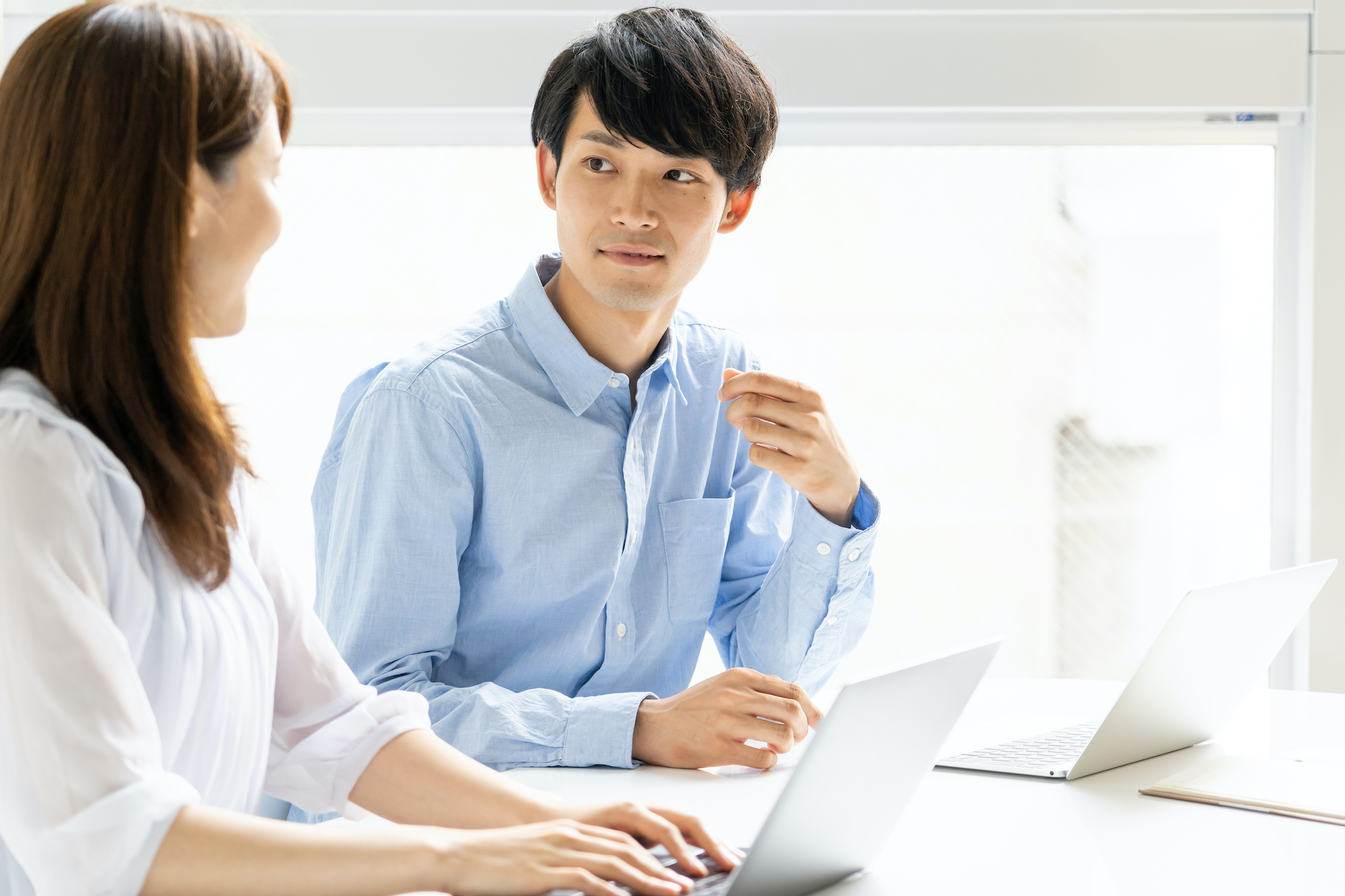 日本人の男女がオフィスで会話している様子