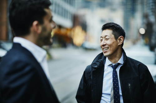 道端で話すスーツを着た日本人男性