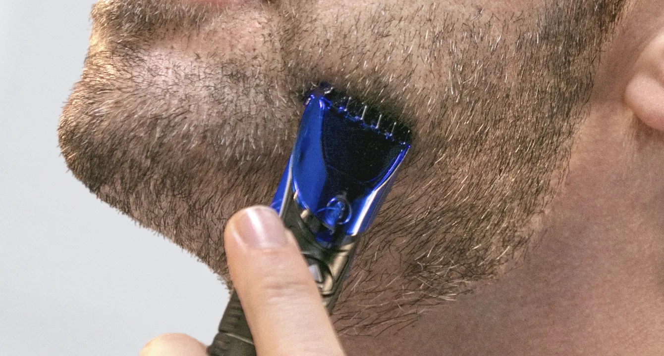 Un hombre recortándose la barba