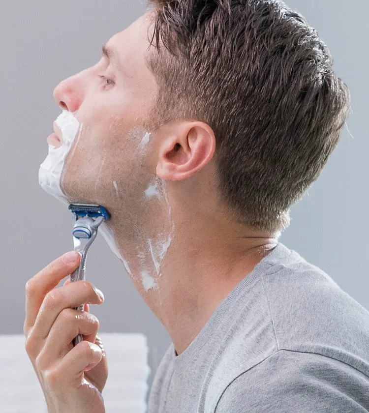 Un hombre afeitándose con una maquinilla Gillette