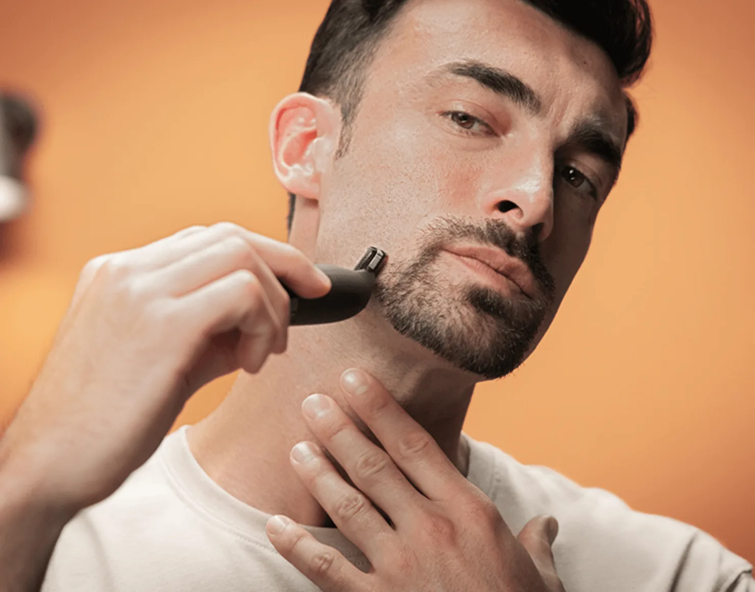 Un hombre recortándose la barba