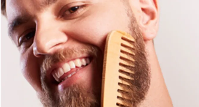 Un hombre peinándose la barba