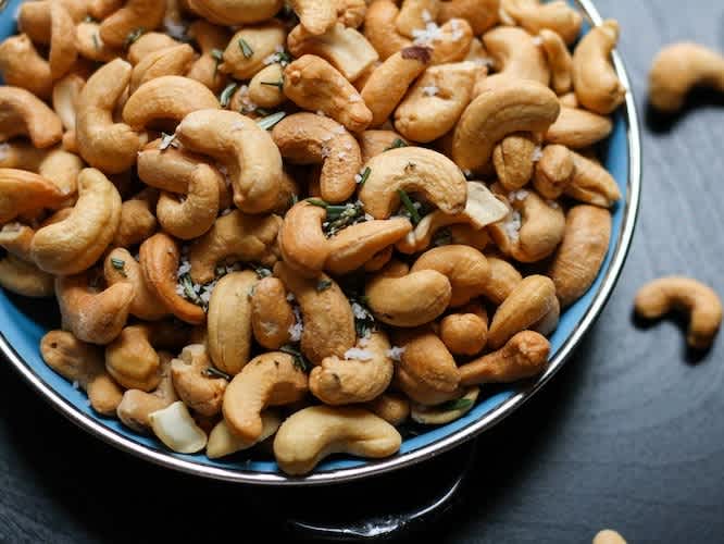 cashews in a blue bowl on a black background