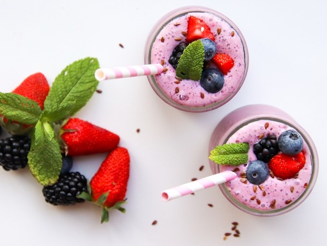 Overhead shot of two berry smoothies on a white background