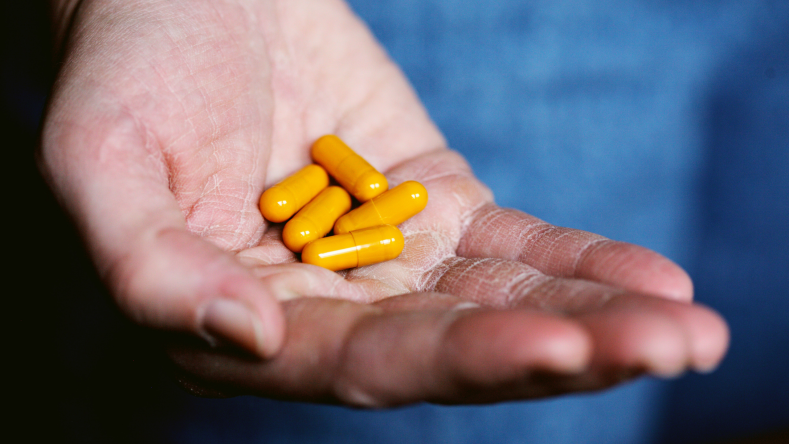 yellow supplements in one hand