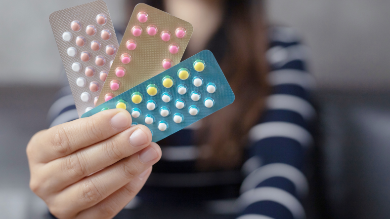 woman holding a pack of birth control pills