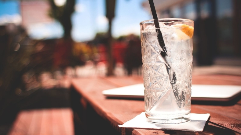 Sparkling water with a lemon wedge on a wooden table