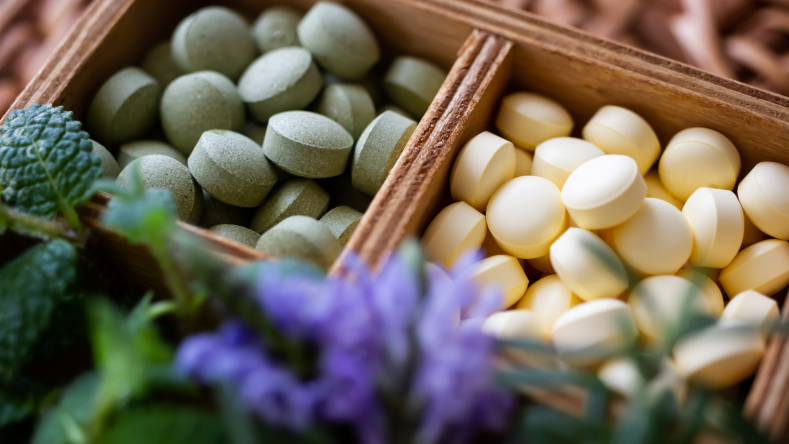 green and white supplements in a wooden box