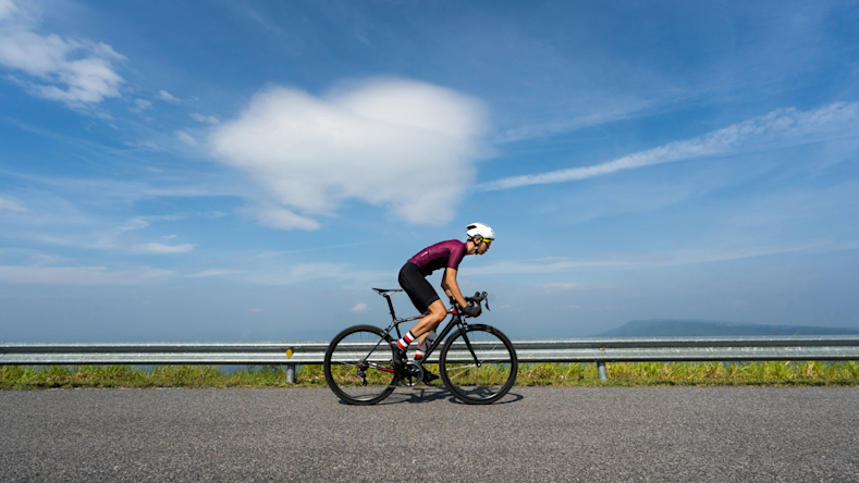 Cyclist in a burgundy jersey cycling on the road