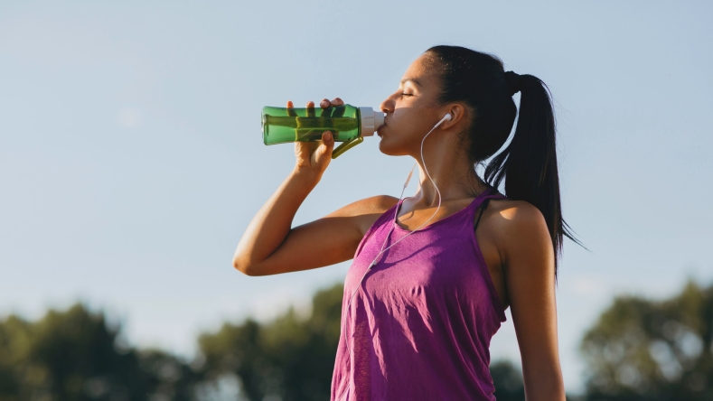 woman runner drinking water