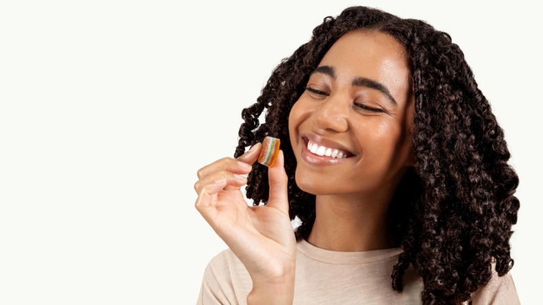 woman with black hair holding Elo smart gummies