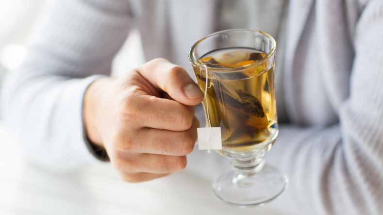 man drinking a cup of green tea