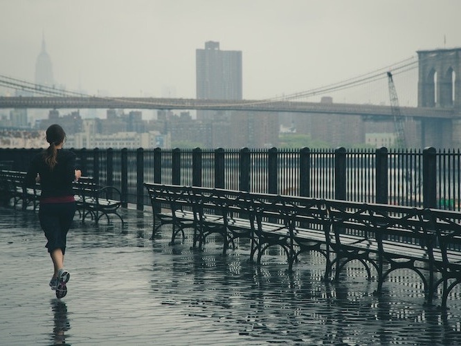 Female runner jogging in new york with Brooklyn Bridge in the background