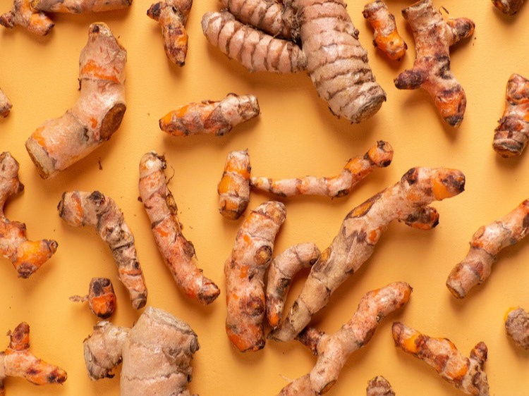 Turmeric root on an orange background