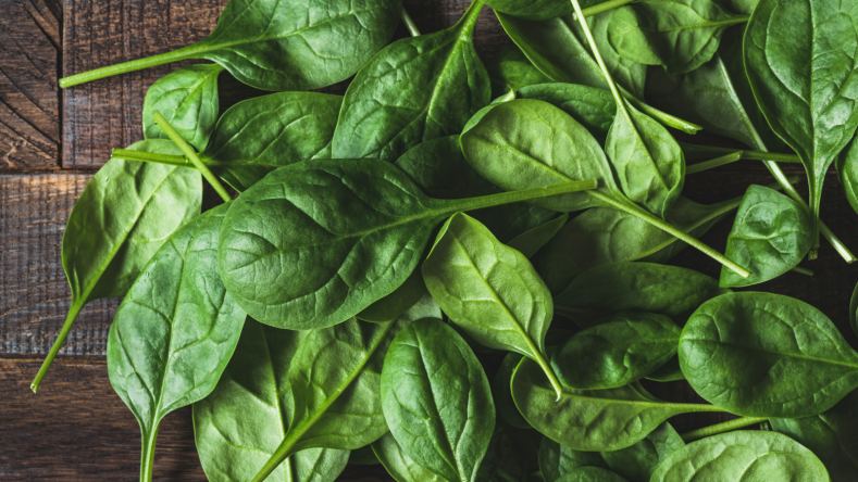 Baby spinach on a wooden background