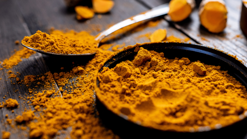 Turmeric in a black dish on a wooden table