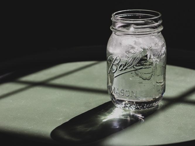 Water in a mason jar on a green table