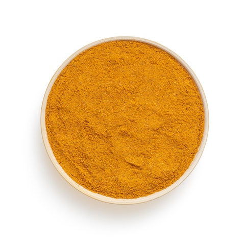 Ground turmeric in a white bowl