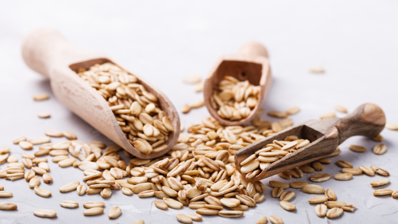 whole grain oats in wooden spoons