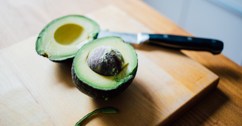 avocado sliced in half on a cutting board