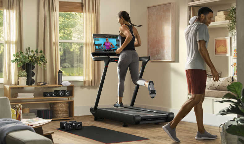 Woman running on a peloton treadmill