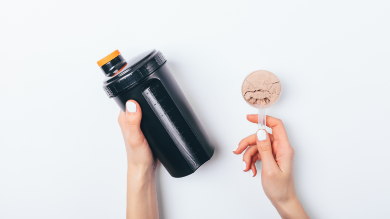 A scoop of protein powder and a protein shake bottle