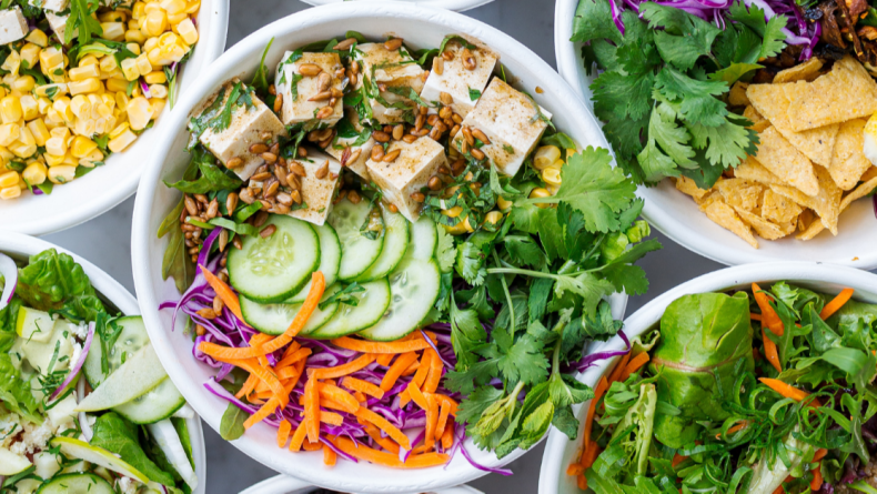green salad in bowl with tofu, cucumber, carrots, cabbage, and cilantro