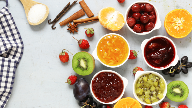 assortment of fruit and jam on a white background