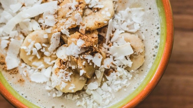 Bowl of oatmeal topped with banana, cinnamon and coconut