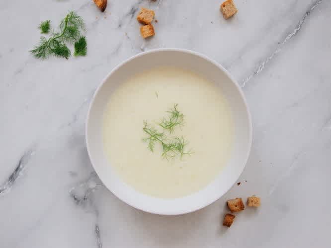 White soup with dill on a marble background
