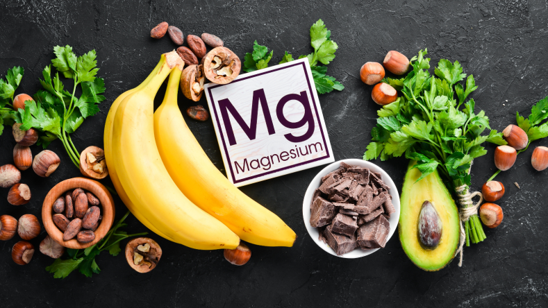 Magnesium rich foods including bananas, chocolate and nuts on a black background