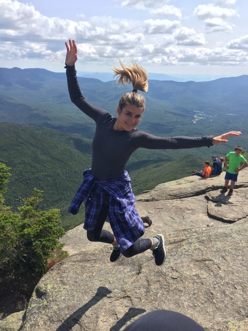 Alayna Hutchinson jumping with mountains in the background