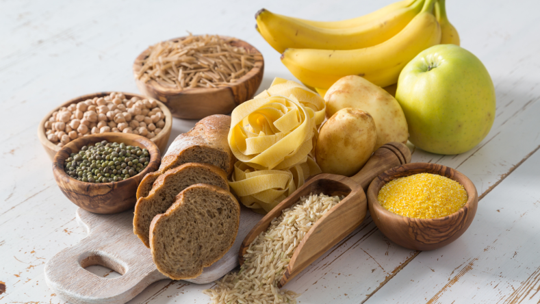 Various forms of carbohydrate on a wooden board on a white background