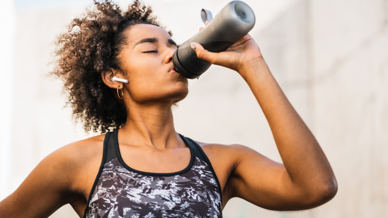 woman drinking out of a water bottle