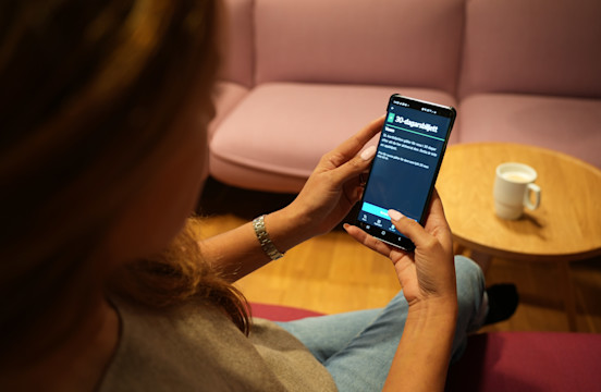 Kvinna som håller i en mobil och håller på att köpa en 30-dagarsbiljett ...