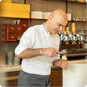 A man scoops gelato into a cone