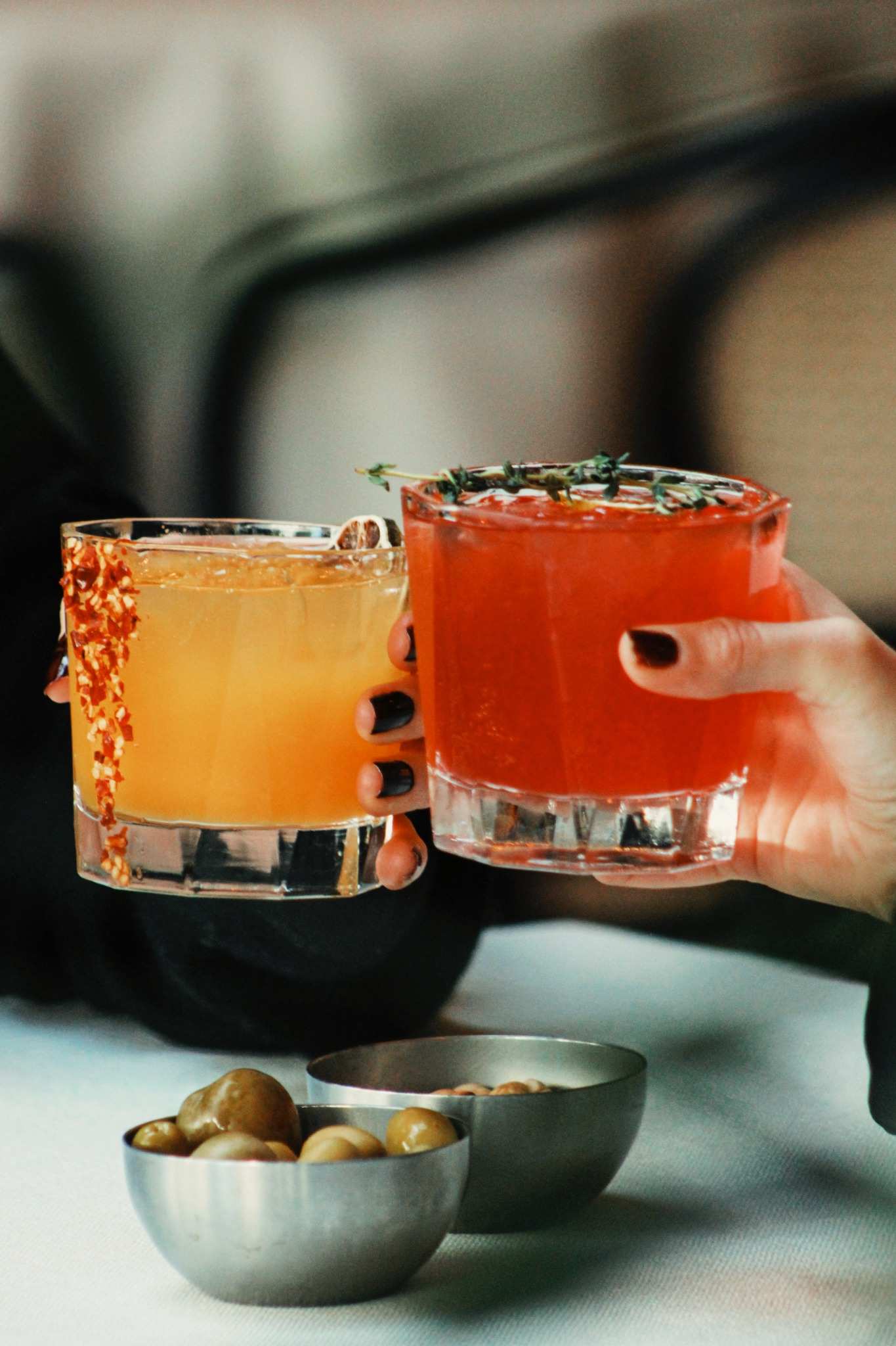 Close up of person holding two cocktails