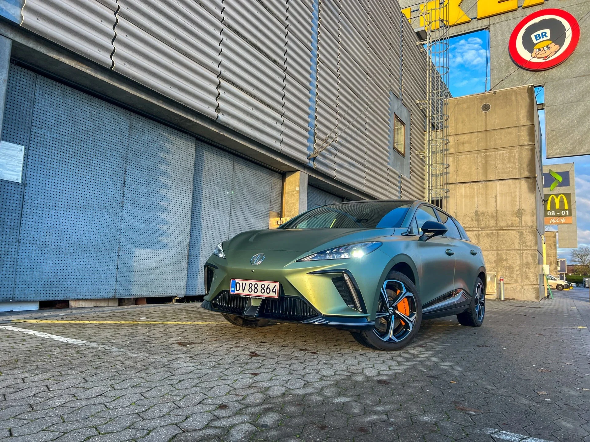 Grön mg4 xpower parkerad bredvid byggnad på stengata