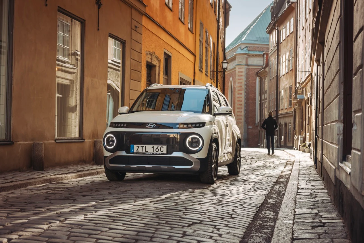 Vit hyundai inster på kullerstensgatan mellan hus