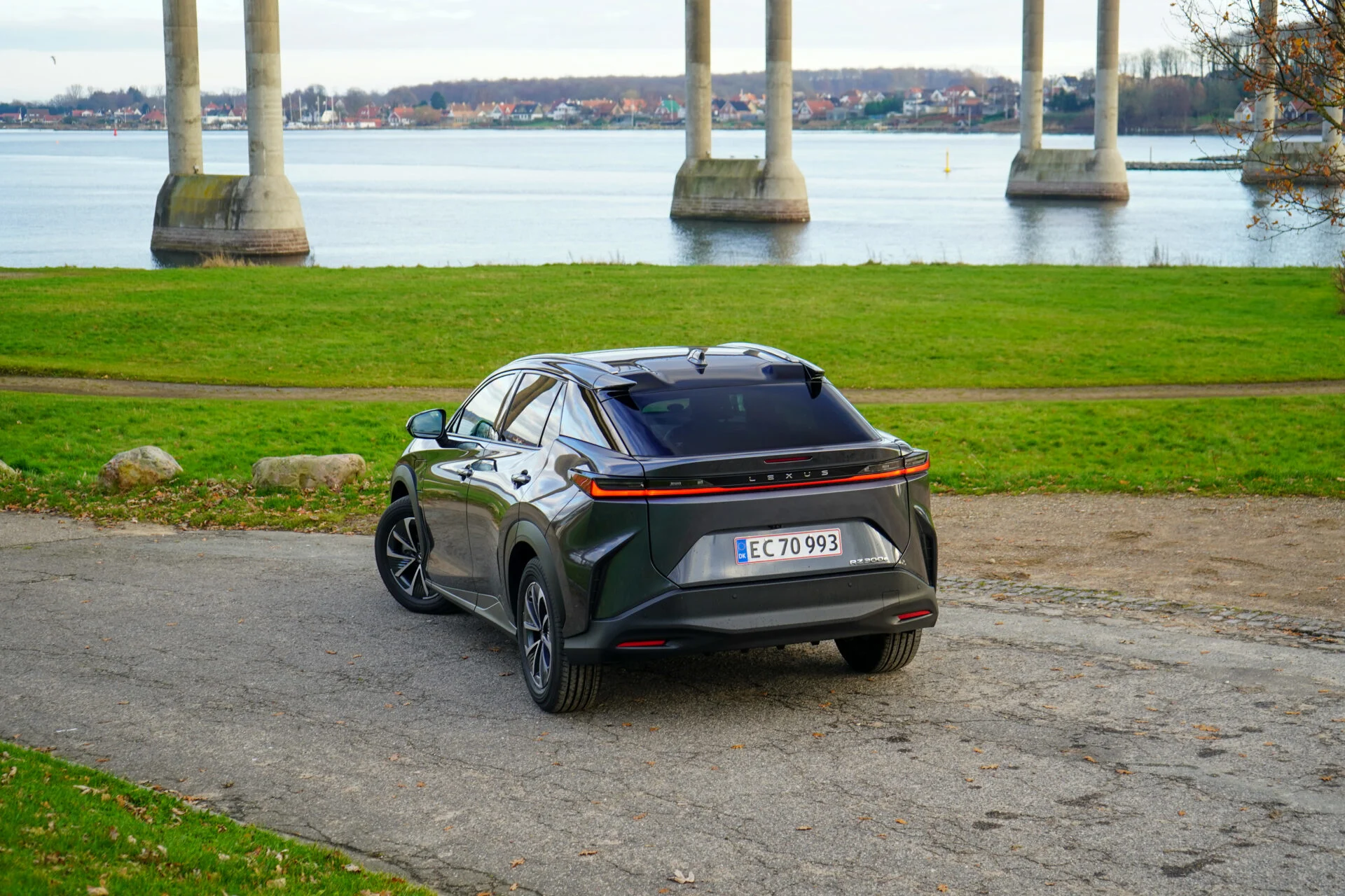 Mörk Lexus sedd bakifrån parkerad nära bro