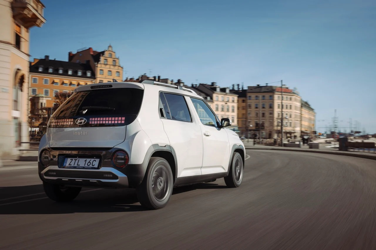 Vit Hyundai Inster snett bakifrån på stadsväg