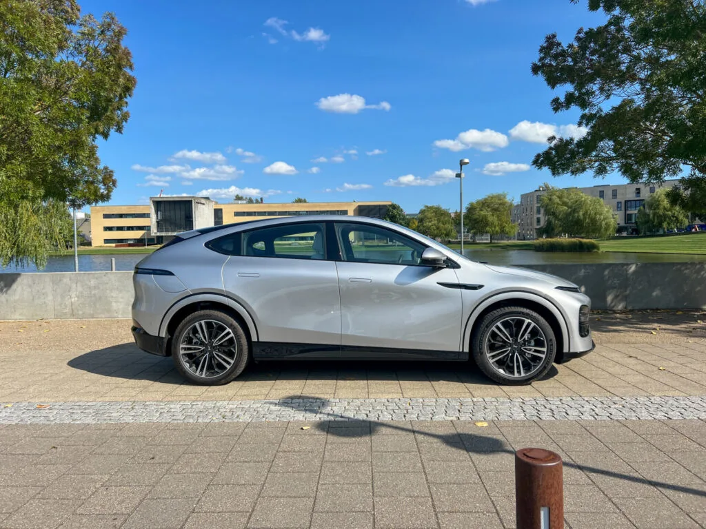 Grå Xpeng G6 parkerad på stenlagd yta